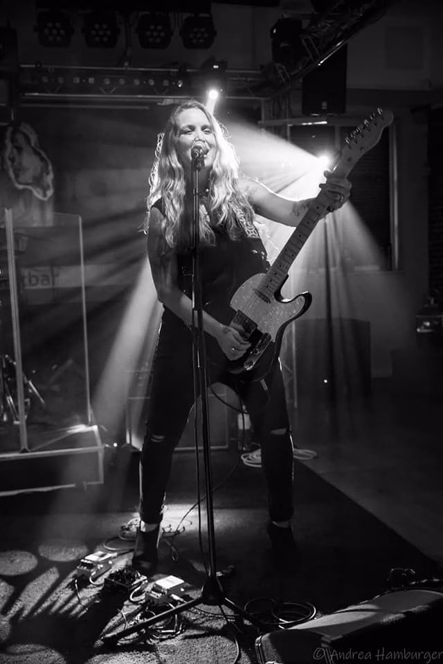Sarah Smith performing with two spotlights behind her.